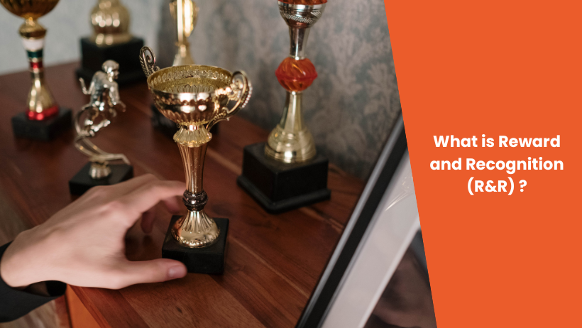 An image of a hand reaching for awards, an orange overlay with the blog title "What is Reward and Recognition?"